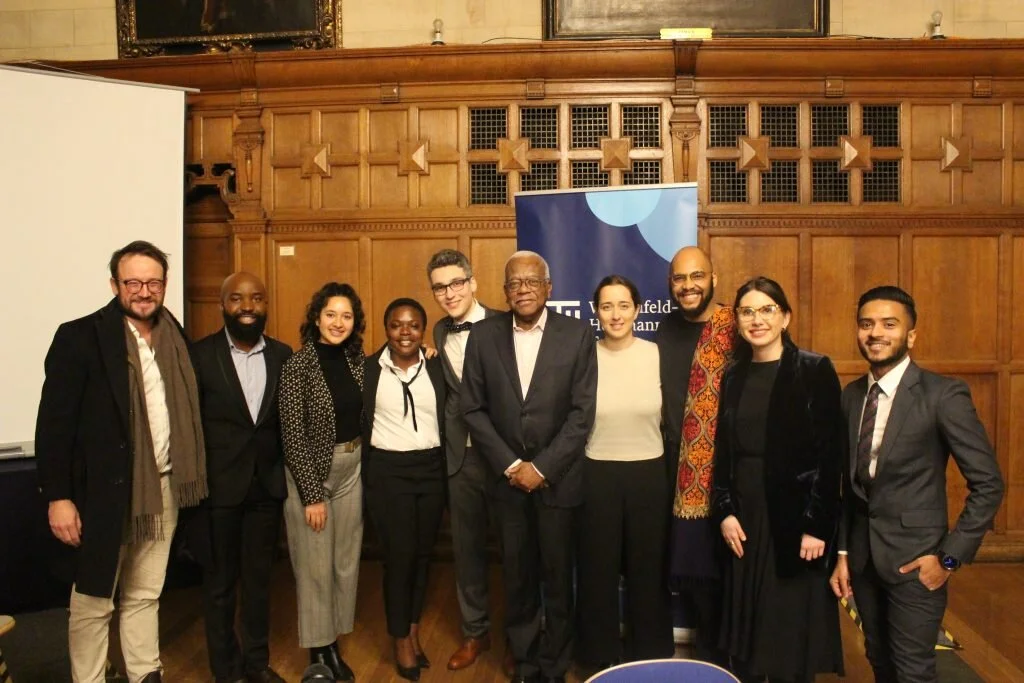  The debating team from left to right: Nikolas Kirby (WHT advisor and  debating coach), Keith Mundangepfupfu (proposition), Bivishika Bandari  (proposition), Arlette Nyembo (opposition), Pablo Marzocca  (proposition), Sir Trevor McDonald ( Chair), Martina Lejtreger  (manager), Usuta Kavari (facilitator), Oksana Matiyash (opposition),  Minah Faiz Rashad (opposition). 